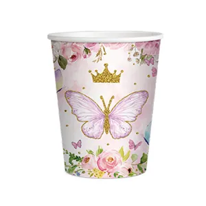 Détail d'un motif de papillon et de couronne dorée sur un gobelet en papier de fête