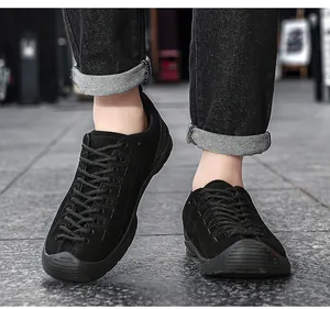 Détail de chaussures de randonnée en daim noir pour hommes portées avec un jean noir