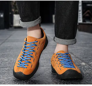 Vue détaillée de chaussures d'extérieur en daim orange avec lacets bleus et embout