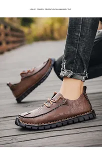 Detail view of men's casual brown leather shoes on an outdoor wooden boardwalk