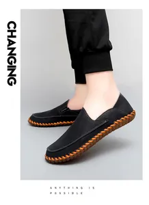 Close-up of men's casual black loafers with orange handmade stitching.