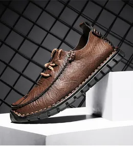 Detail view of brown leather men's casual shoe showing grain texture and rubber sole