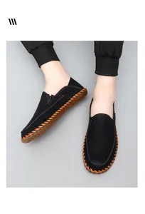 Close-up detail of handmade black leather loafers with orange stitching and gum sole