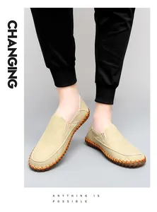 Macro view showing the intricate handmade orange stitching on tan leather loafers
