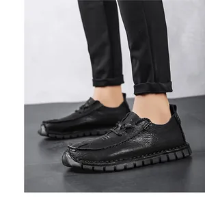 Detail view of black men's casual leather shoes with textured finish and soft soles.
