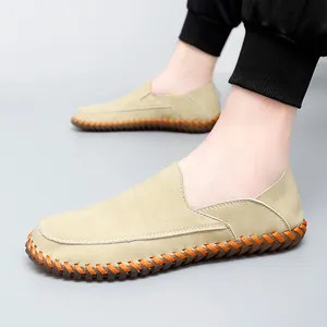 Handmade men's beige leather driving loafers with orange contrast stitching details.