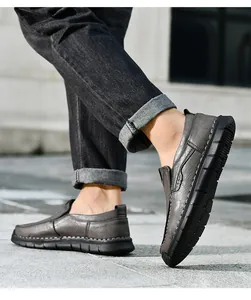 Detaillierte Seitenansicht grauer handgenähter Freizeit-Slipper aus Leder mit Jeans