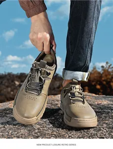 Close-up view of durable brown leather outdoor hiking shoes on natural rocky terrain