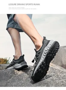 Dettaglio di scarpe sportive outdoor traspiranti in mesh nero per uomo su roccia