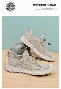Detail van ademende beige mesh herensneakers in een buitenomgeving met zand.