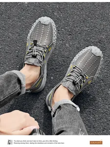 Detailweergave van grijze ademende mesh herensneakers op een donkere asfaltweg