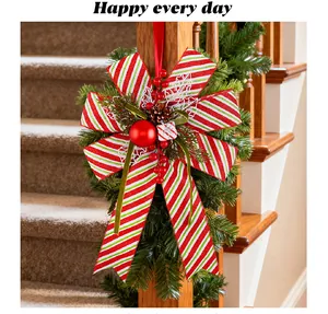 Festive red and white striped Christmas bow ornament hanging on a staircase railing