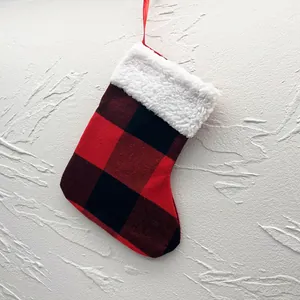 Detailed view of red and black buffalo plaid Christmas stocking with plush white trim