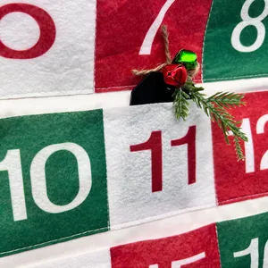 Nahaufnahme eines Filz-Weihnachtskalenders mit roten und grünen Taschen für den Advent
