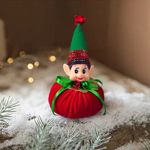 Macro detail of a festive Christmas elf ornament with red velvet body and green ribbon