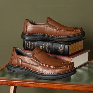 Detailed side view of premium brown leather slip-on loafers for men on books