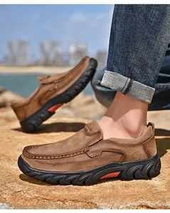 Close-up of brown frosted cowhide leather men's casual outdoor shoes on rocky terrain.