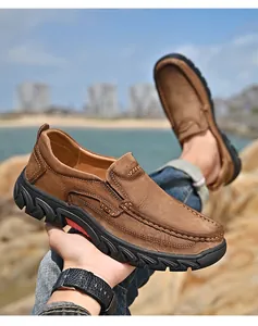 Close-up of brown nubuck leather men's loafers in a scenic outdoor coastal setting