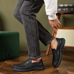 Close-up view of a man wearing black leather slip-on loafers with soft textured soles
