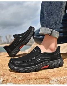 Close-up of men's black nubuck leather outdoor slip-on shoes on rocky ground