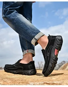 Detailed view of black suede outdoor loafers with thick non-slip soles on rocks