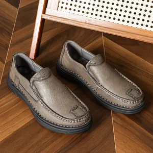 Classic grey leather loafers for men with slip-on design on a stylish wooden floor