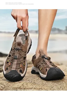 Détail des sandales d'extérieur en cuir et mesh marron pour hommes sur rochers