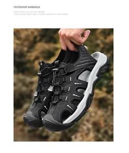 Detail shot of black men's closed-toe outdoor sandals being held by hand