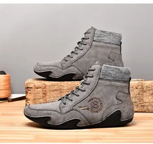 Vista detallada de botas Martin de ante gris con cuello de punto y bordado de dragón