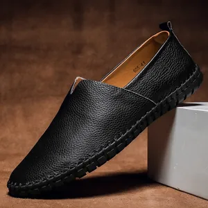 Primo piano di mocassini in pelle martellata nera con cuciture a mano.