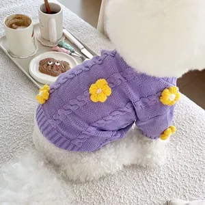 Close-up detail of purple cable knit dog sweater with yellow crochet flower ornaments