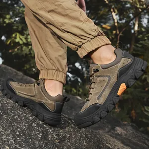 Detailed view of men's brown outdoor hiking shoes on rocky terrain