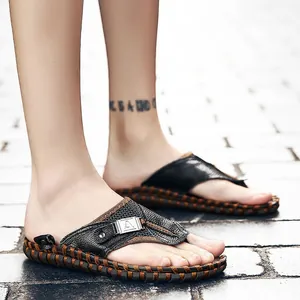 Hoogwaardig detail van ademende zwarte leren slippers voor heren op een stenen pad