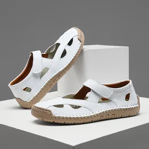 Close-up detail of white genuine leather hollow-out sandals with durable rubber soles