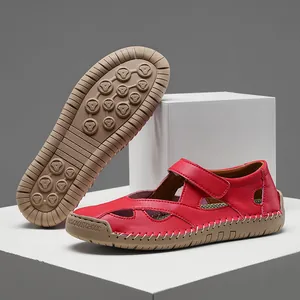 Detailed view of red leather hollow-out sandals showing textured non-slip rubber sole.
