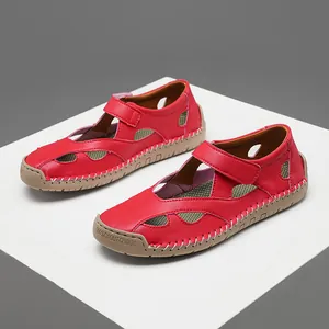 Close-up of red leather cutout sandals with durable rubber sole and velcro strap closure