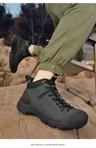 Men's durable black outdoor hiking boots with anti-slip thick soles on rocky terrain