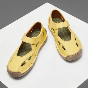 Top view detail of yellow hollow leather sandals featuring secure velcro strap closure