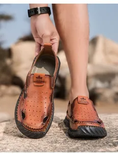 Detail van bruine ademende lederen sandalen voor heren met een stevige en gestikte loopzool.