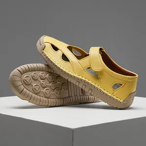 Detail view of yellow genuine leather women's sandals with cut-out design and rubber sole