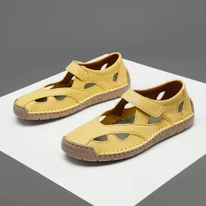 Detailed side view of yellow hollow-out leather sandals with velcro strap