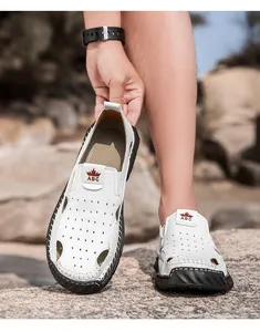 Detailopname van witte ademende herensandalen met een geperforeerd ontwerp.