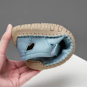 Close-up showing the flexibility of light blue leather hollow-out sandals with rubber sole.