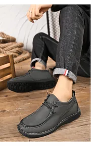 Close-up van grijze leren herenschoenen in Britse stijl met dikke zolen op model