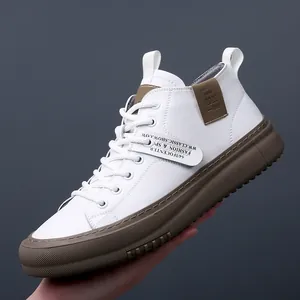 Moderne sneakers alte da uomo in pelle bianca con spesse suole marroni a contrasto.
