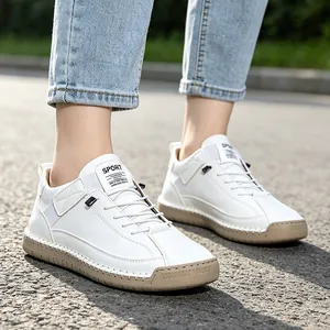 Close-up of white men's mid-top casual sneakers featuring a stitched sole design