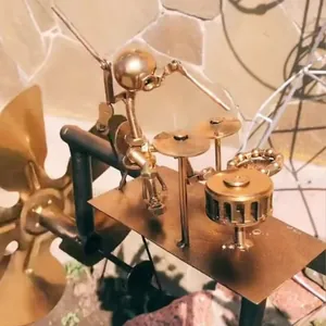 Intricate close-up detail of a handmade metal drummer windmill with a polished gold finish.
