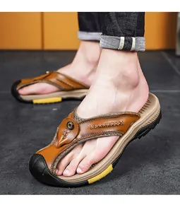 Vista dettagliata di infradito in pelle marrone fatte a mano con cuciture decorative