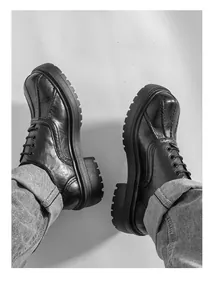 Nahaufnahme von schwarzen Retro-Leder-Loafers mit Plateausohle