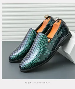 Detailansicht der spitzen Herren-Loafer mit einem lebhaften grünen Schlangenmuster.